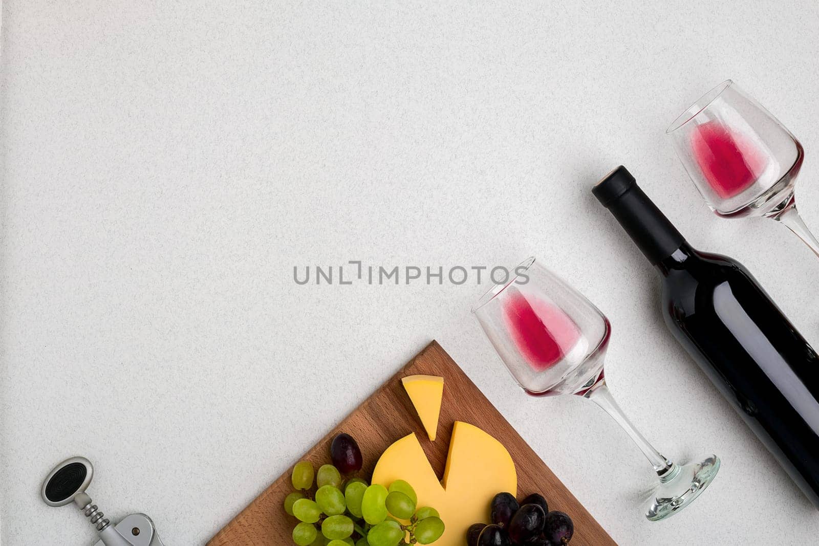 Wine, glasses and corkscrew over white background. Top view with copy space