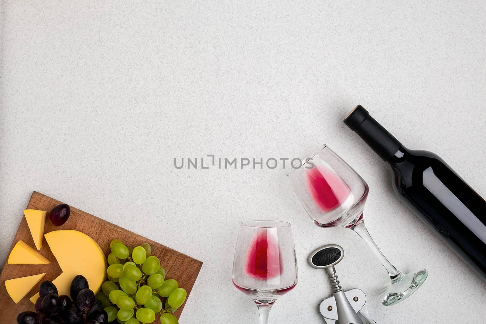 Wine, glasses and corkscrew over white background. Top view with copy space