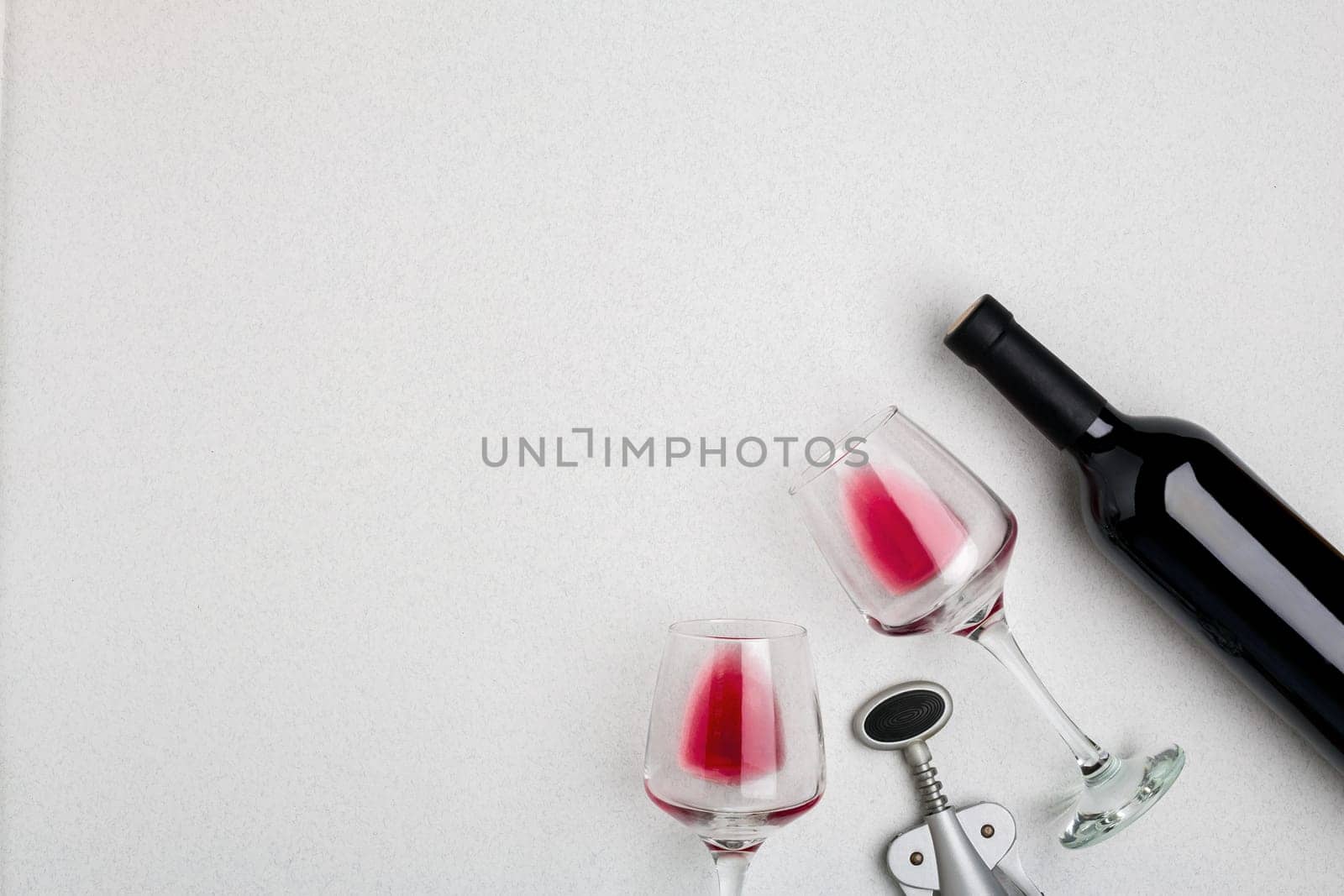 Wine, glasses and corkscrew over white background. Top view with copy space