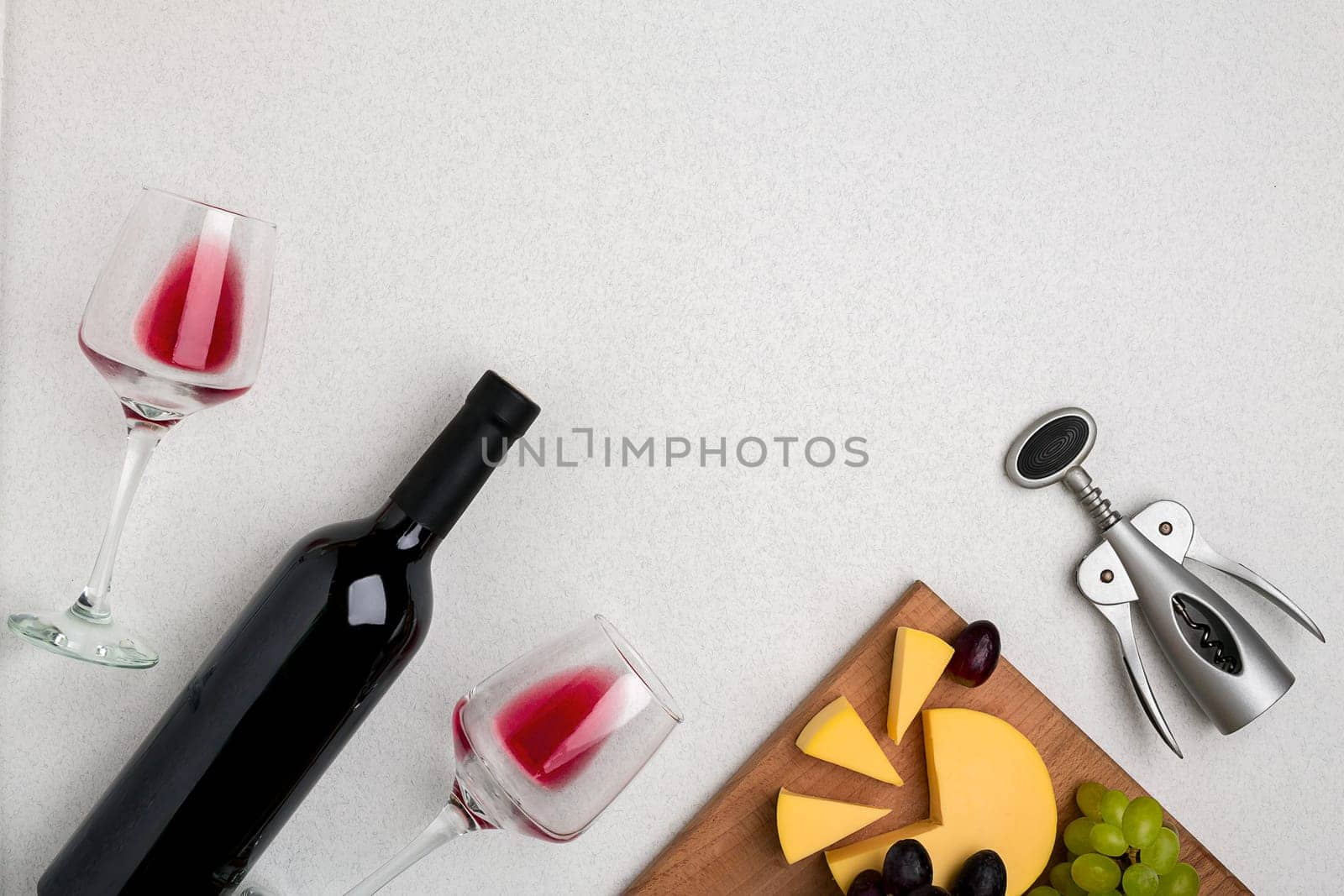 Wine, glasses and corkscrew over white background. Top view with copy space