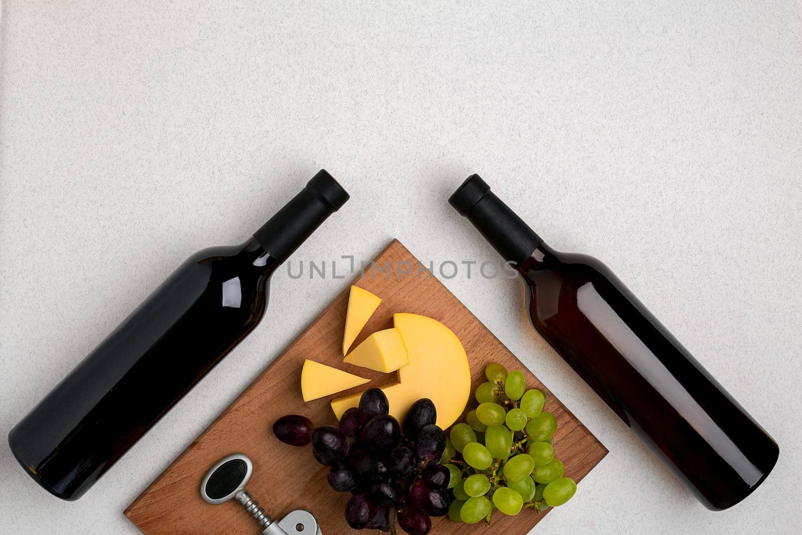 Bottles of red and white wine on white background from top view. Copy space