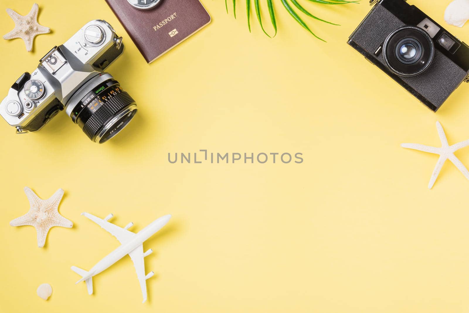 Flat lay top view mockup retro camera films, airplane, leaves, starfish traveler tropical beach accessories on a yellow background with copy space, Vacation summer travel and business trip concept