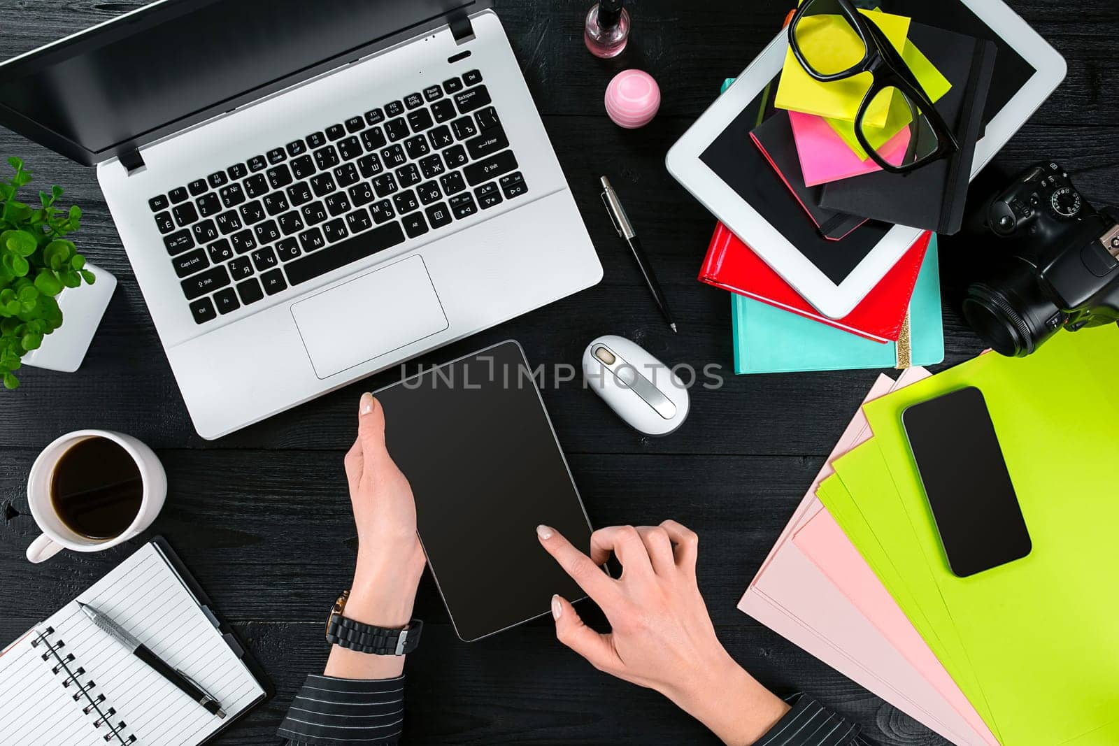 Overhead view of businesswoman working at computer in office against a dark background. Women's hands. Copy space