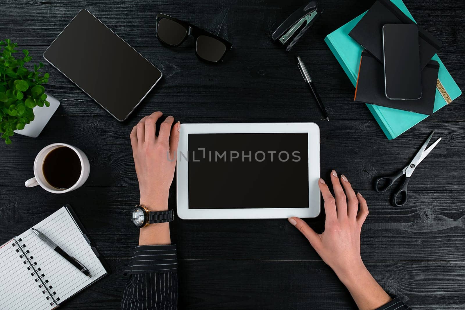 Overhead view of businesswoman working at computer in office against a dark background. Women's hands. Copy space