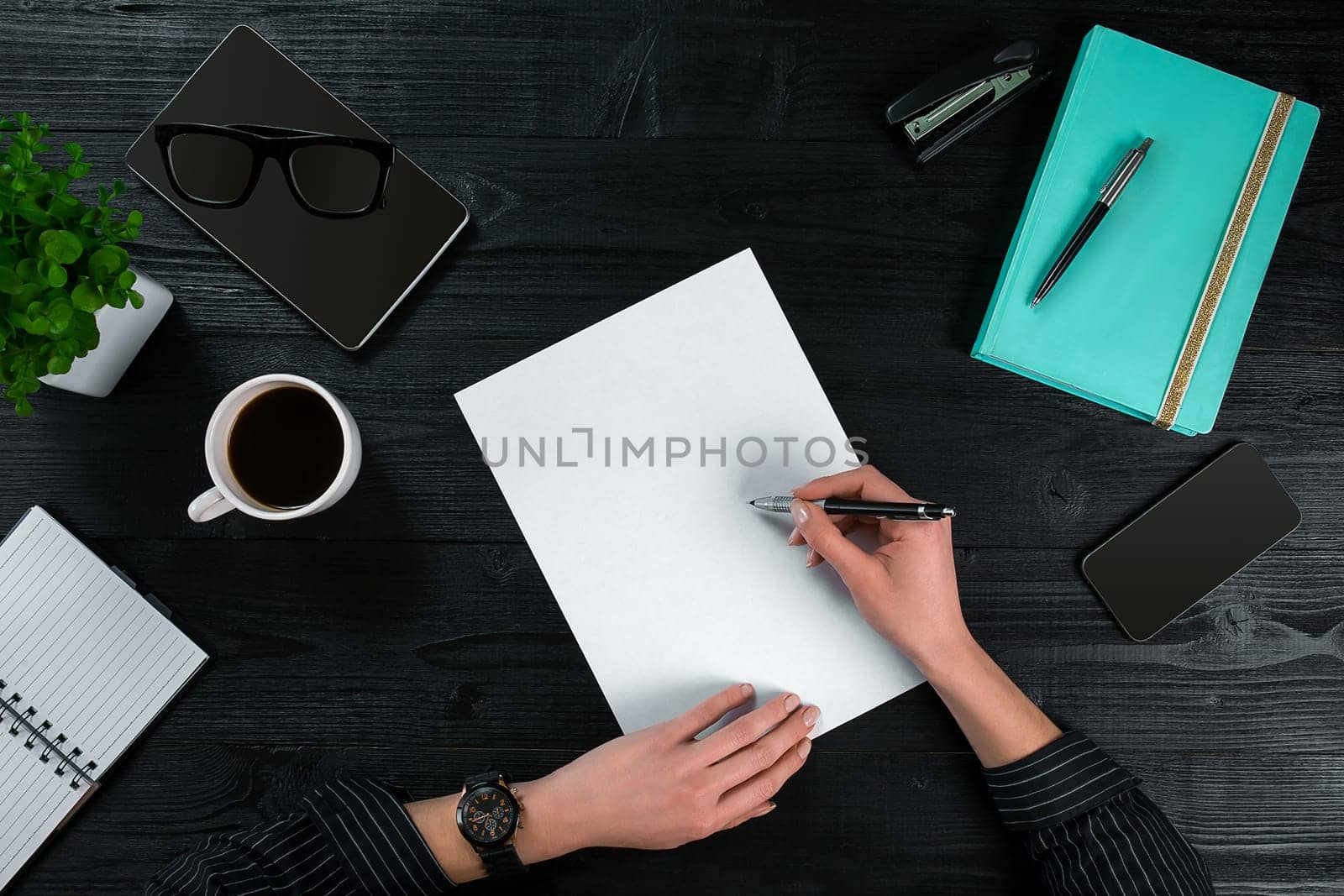 Overhead view of businesswoman working at computer in office against a dark background. Women's hands. Copy space