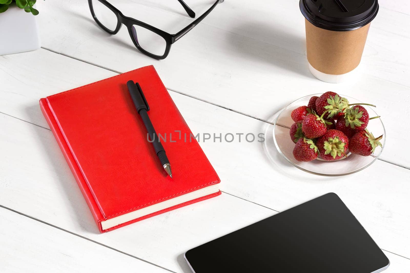 Stylish minimalistic workplace with tablet and notebook and glasses in flat lay style. White background. Top view. Copy space