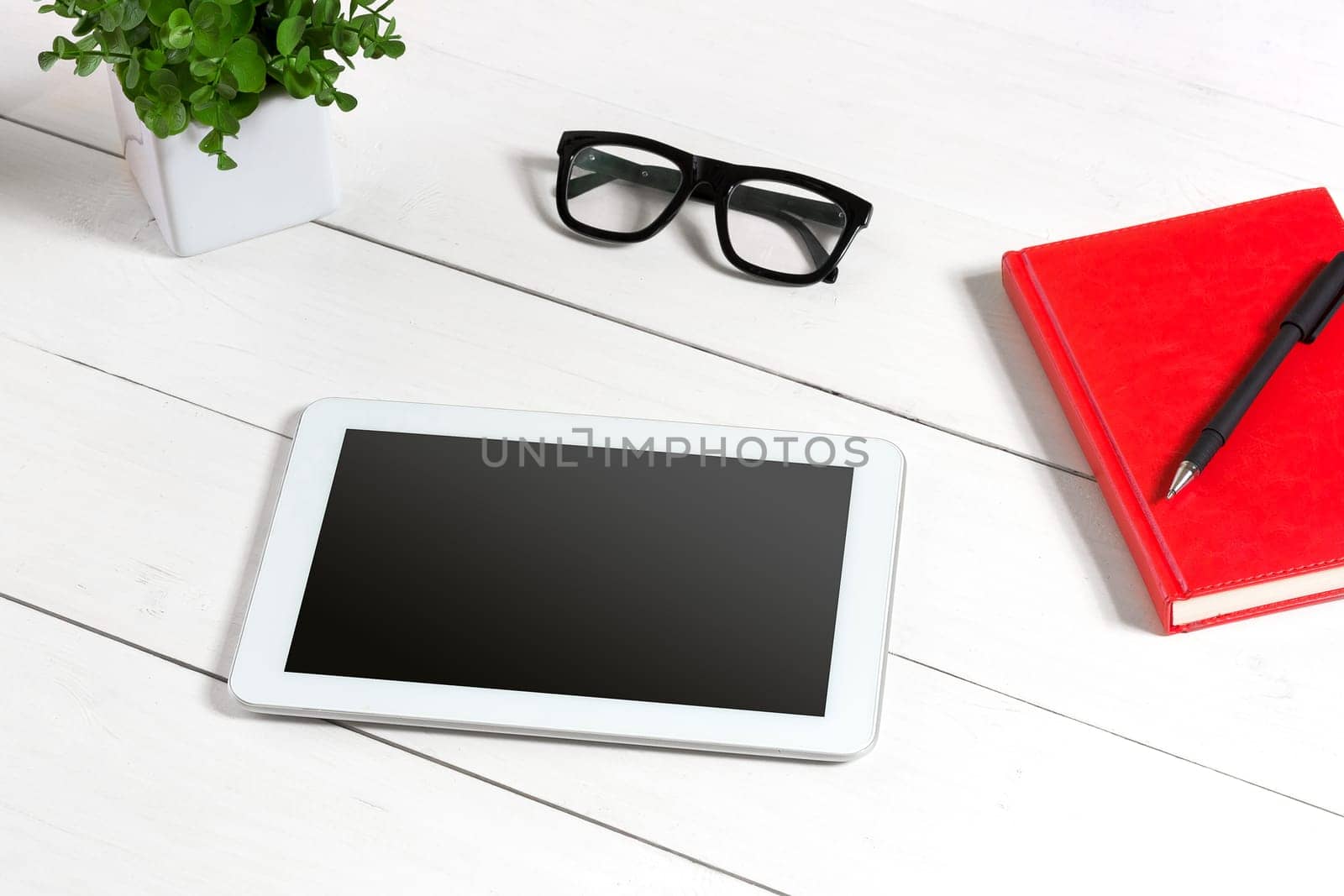 Stylish minimalistic workplace with tablet and notebook and glasses in flat lay style. White background. by nazarovsergey