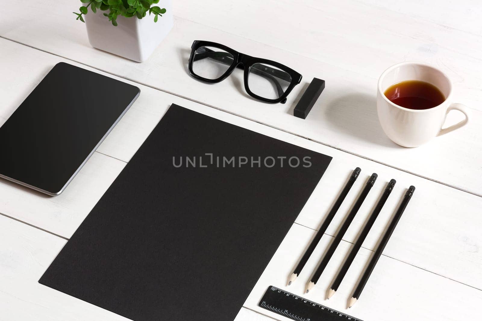 Modern workplace with digital tablet computer and mobile phone, cup of coffee, pen and empty sheet of paper. Top view and copy space for text