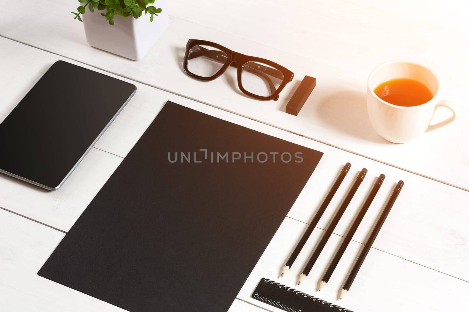 Modern workplace with digital tablet computer and mobile phone, cup of coffee, pen and empty sheet of paper. Top view and copy space for text