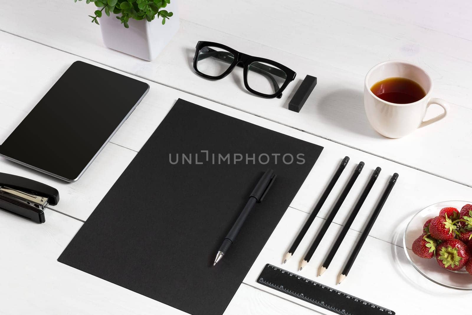 Modern workplace with digital tablet computer and mobile phone, cup of coffee, pen and empty sheet of paper. Top view and copy space for text