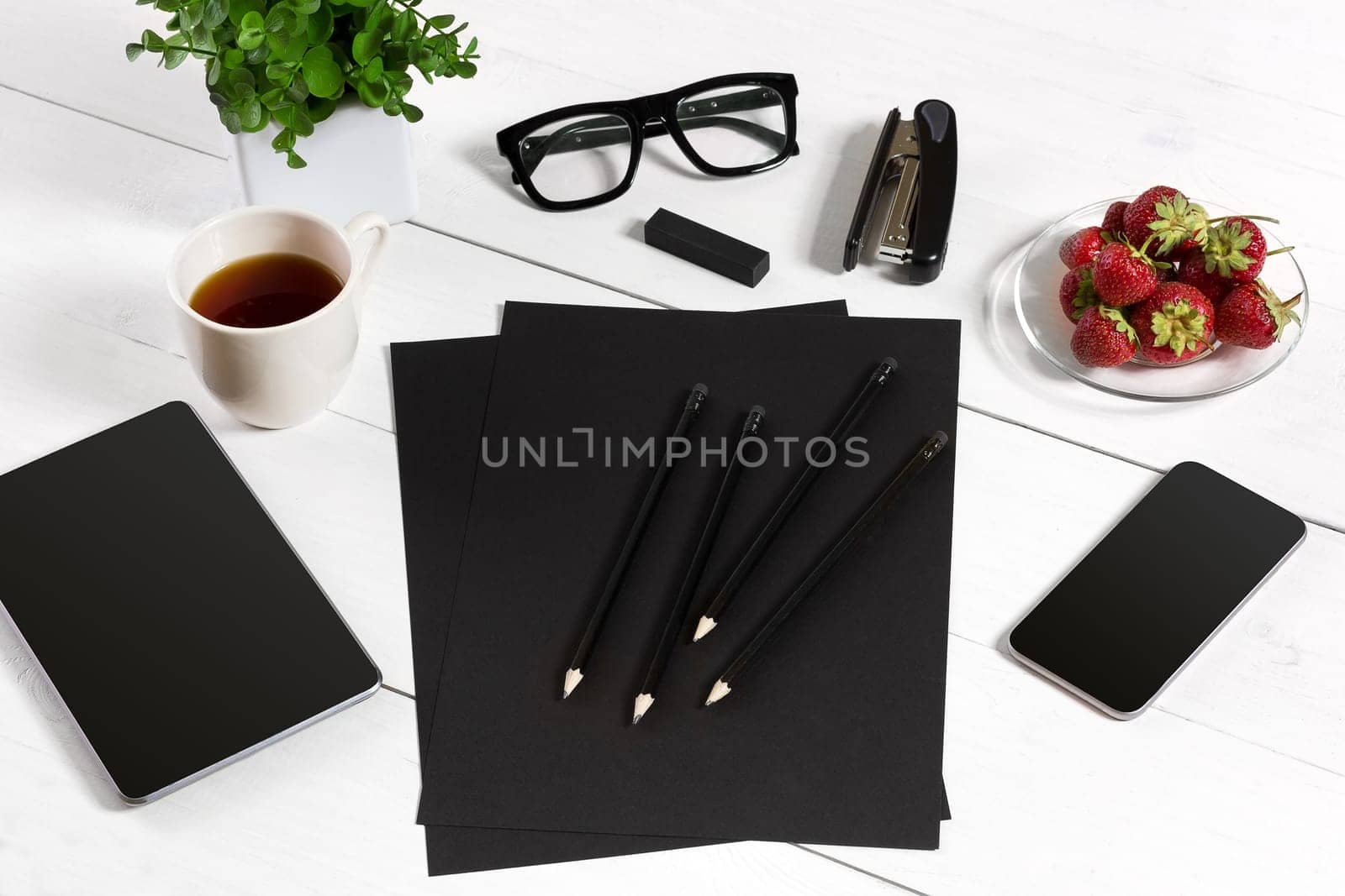 Modern workplace with digital tablet computer and mobile phone, cup of coffee, pen and empty sheet of paper. Top view and copy space for text