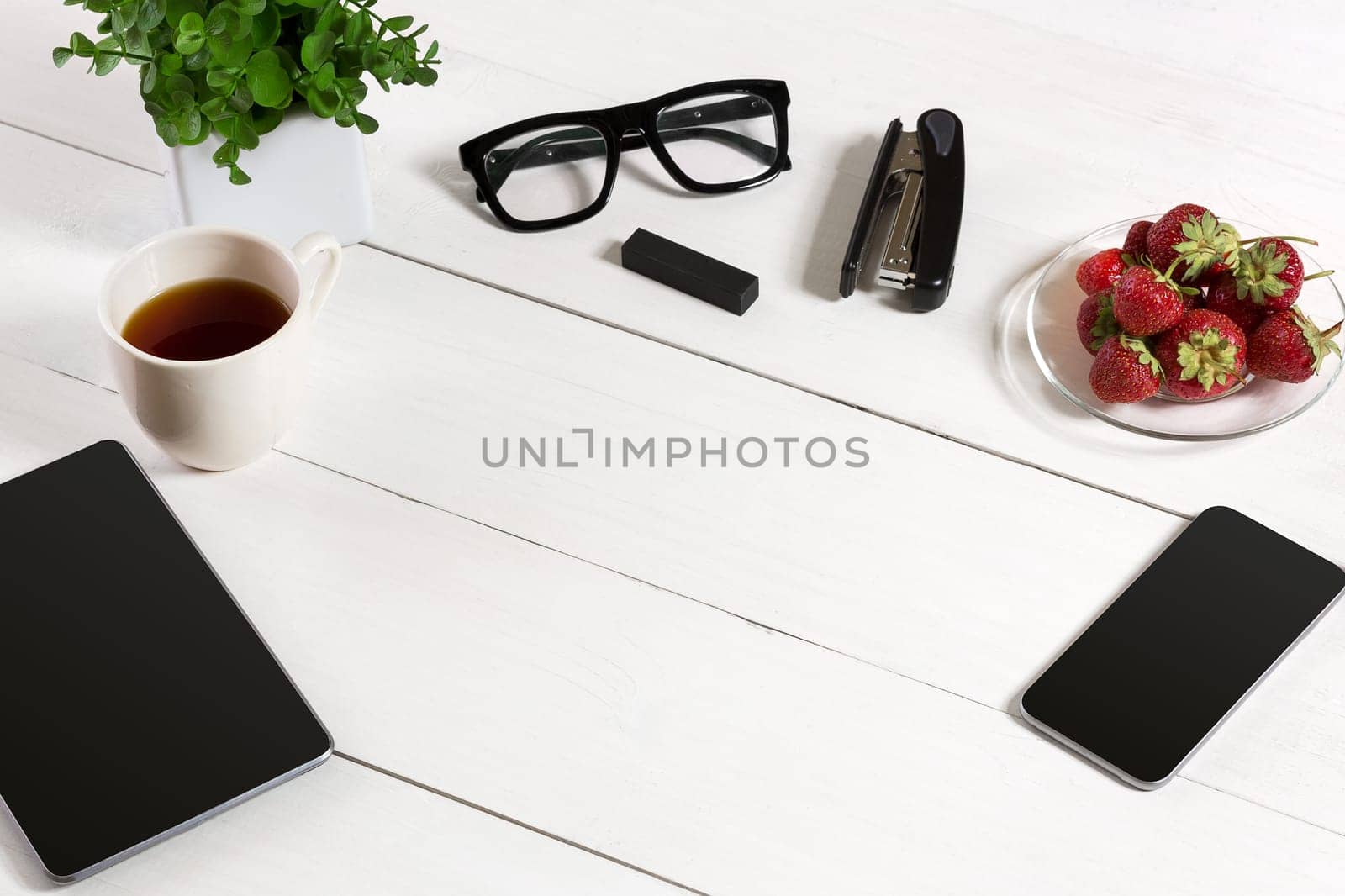 Modern workplace with digital tablet computer and mobile phone, cup of coffee and flower on white background. Top view by nazarovsergey