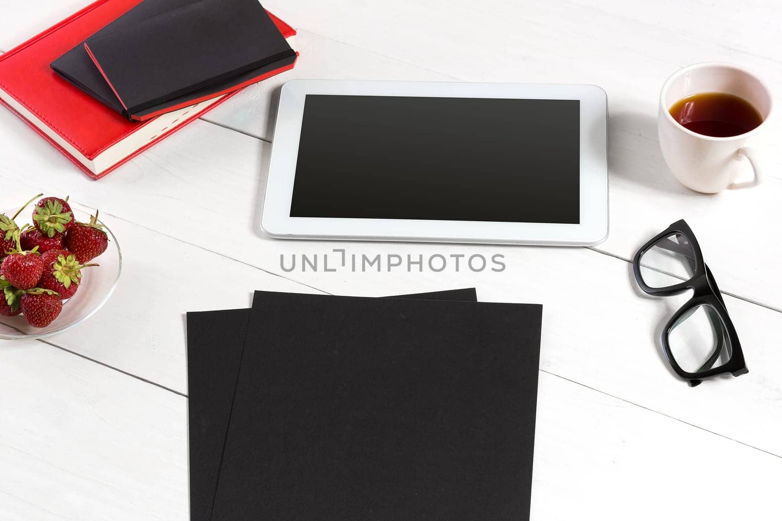 Stylish minimalistic workplace with tablet and notebook and glasses in flat lay style. White background. by nazarovsergey