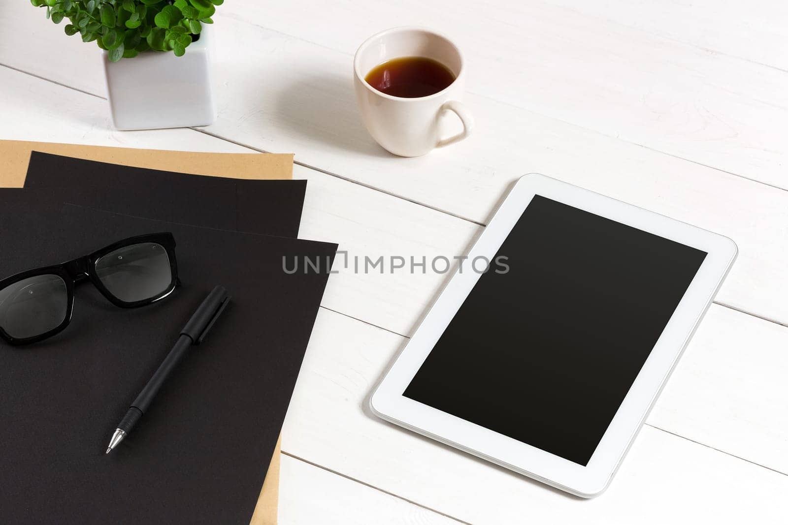 Modern workplace with digital tablet computer and mobile phone, cup of coffee, pen and empty sheet of paper. Top view and copy space for text