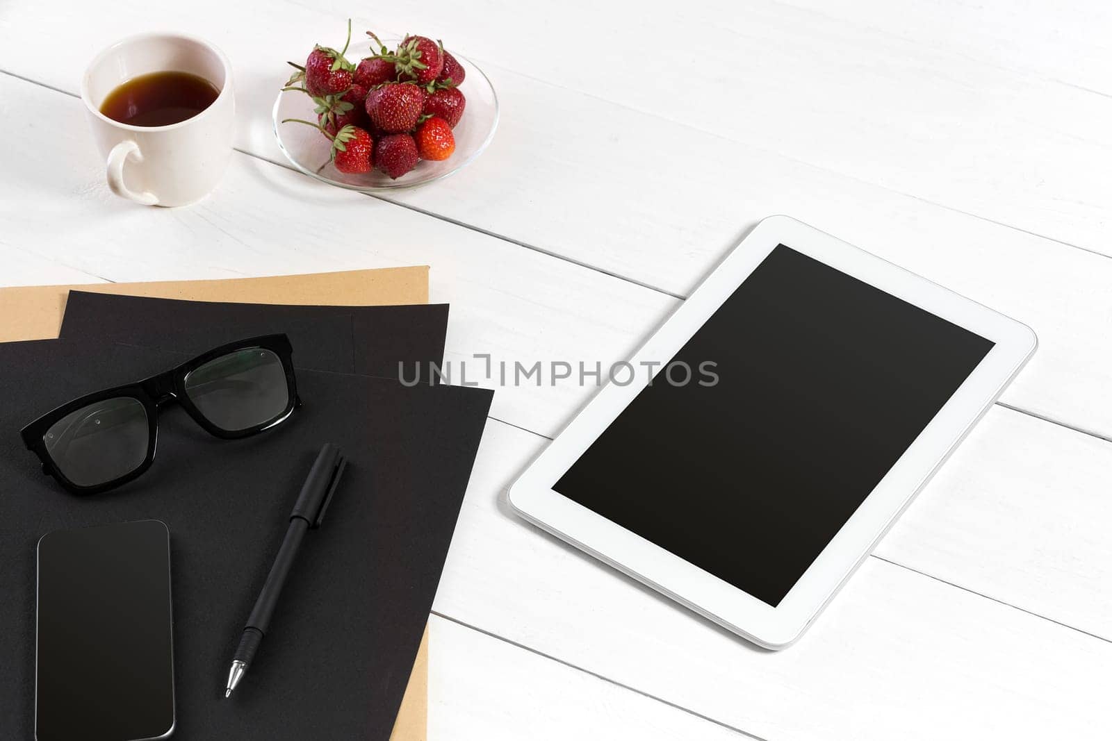 Modern workplace with digital tablet computer and mobile phone, cup of coffee, pen and empty sheet of paper. Top view and copy space for text