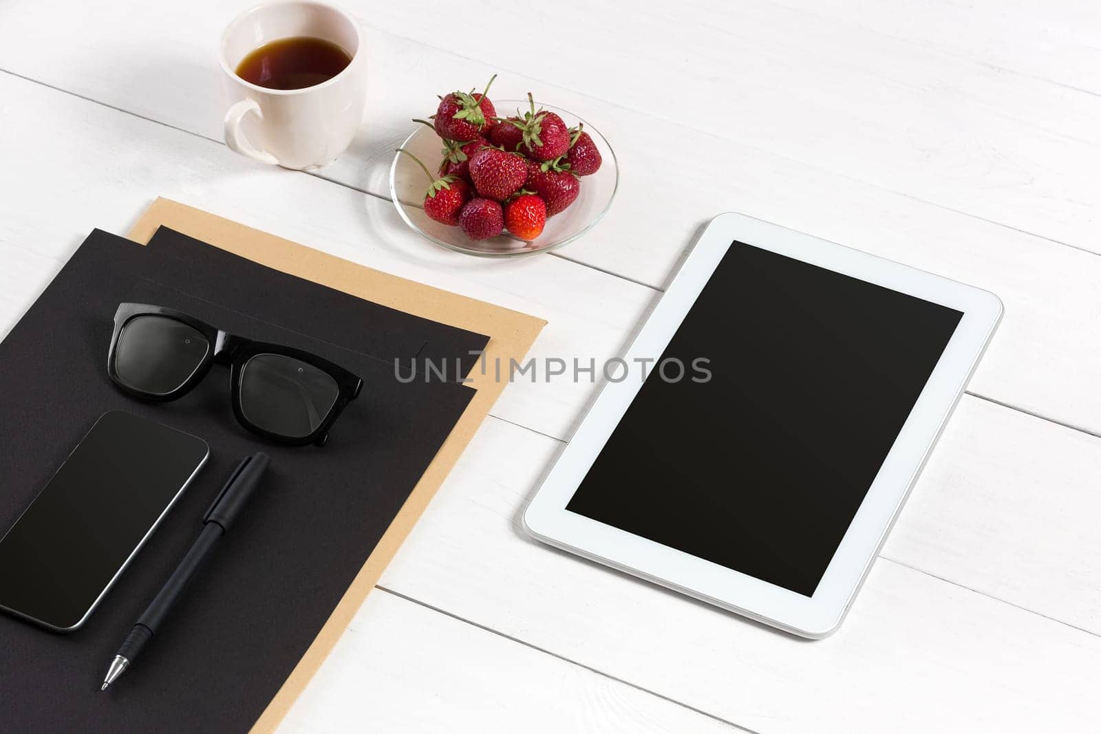 Modern workplace with digital tablet computer and mobile phone, cup of coffee, pen and empty sheet of paper. Top view and copy space for text