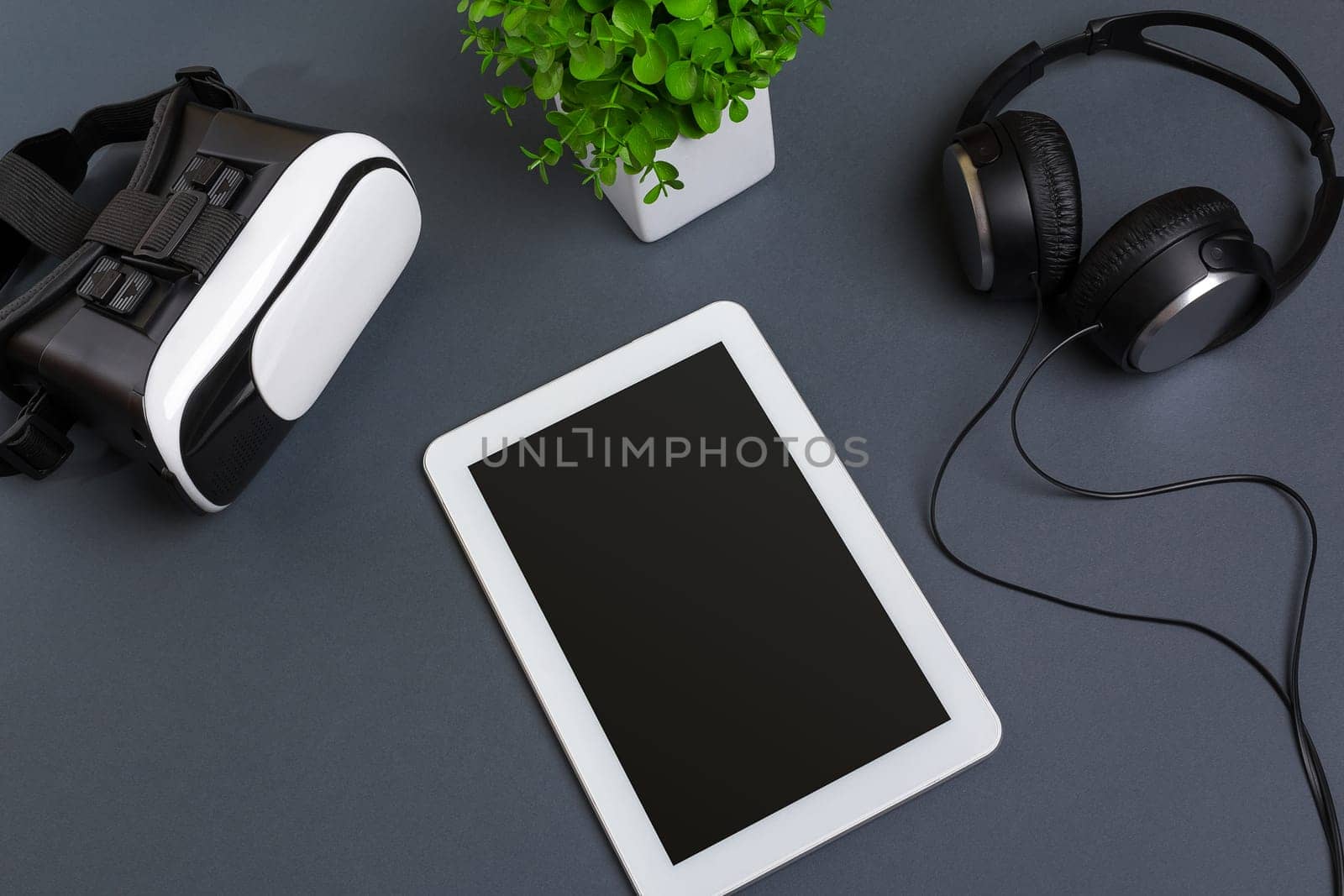 Virtual reality glasses and tablet with headphones on a gray background. Top view by nazarovsergey