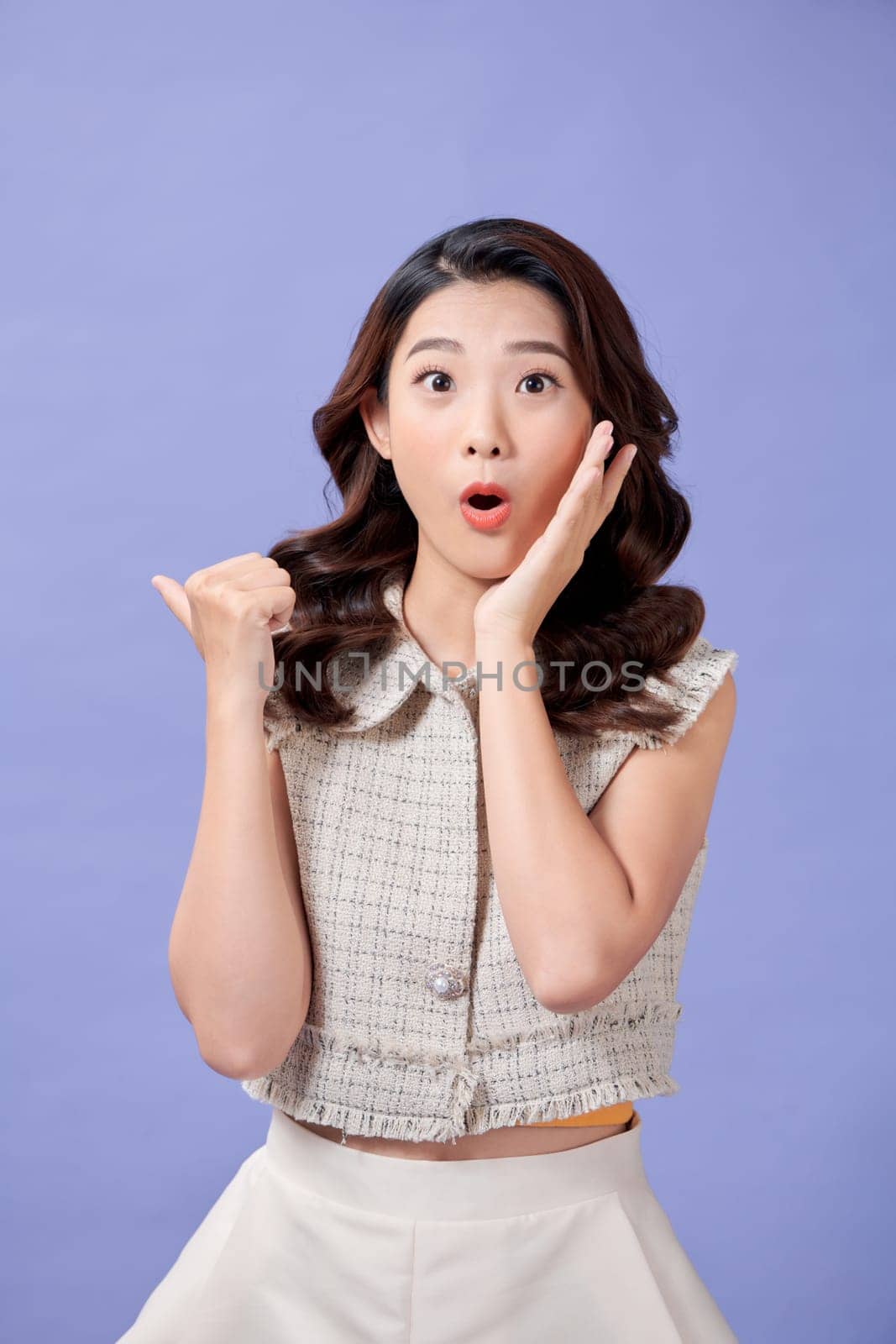 Photo of shiny impressed young lady showing thumb back empty space isolated purple color background