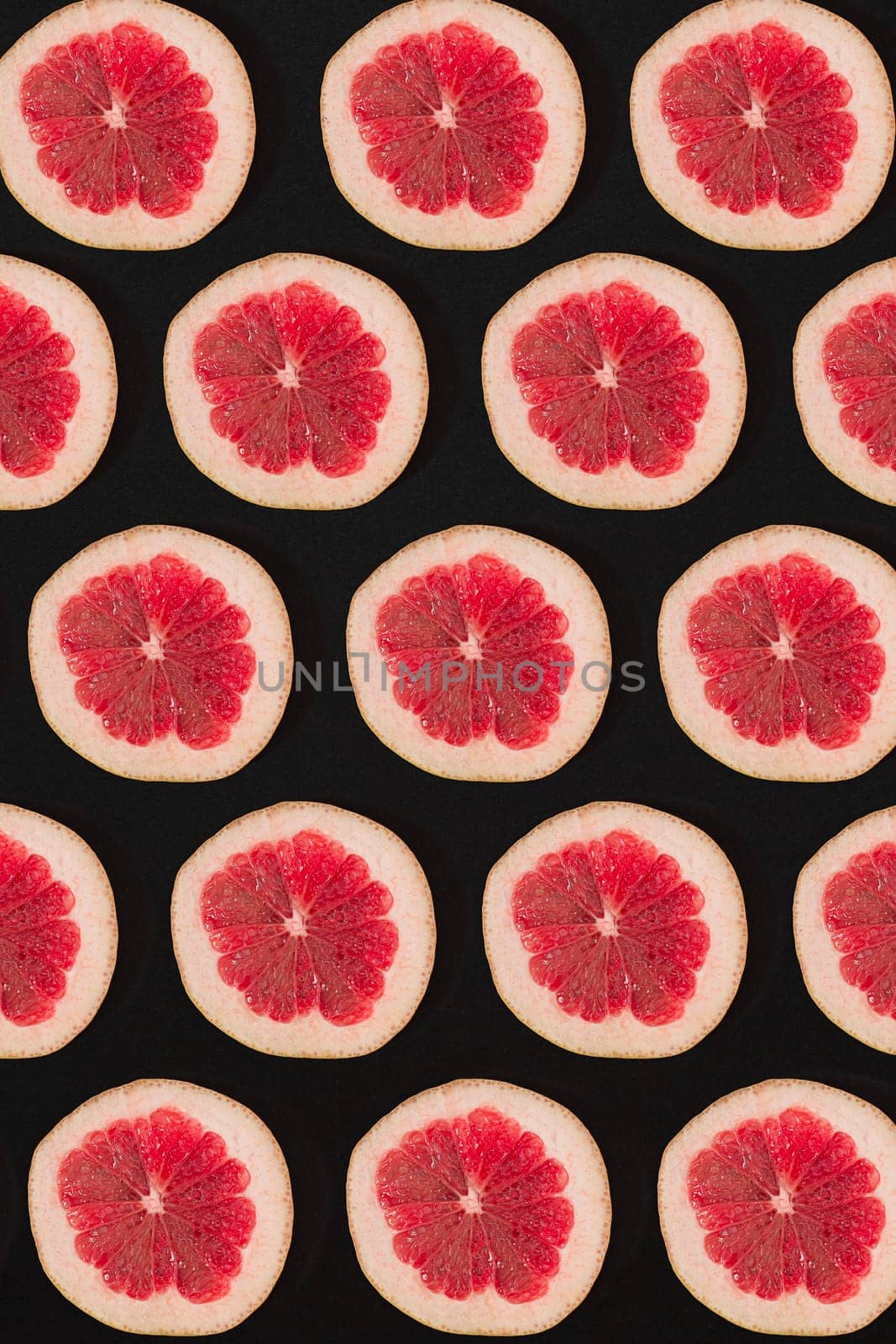 Grapefruit pattern isolated on black background. Flat lay by nazarovsergey
