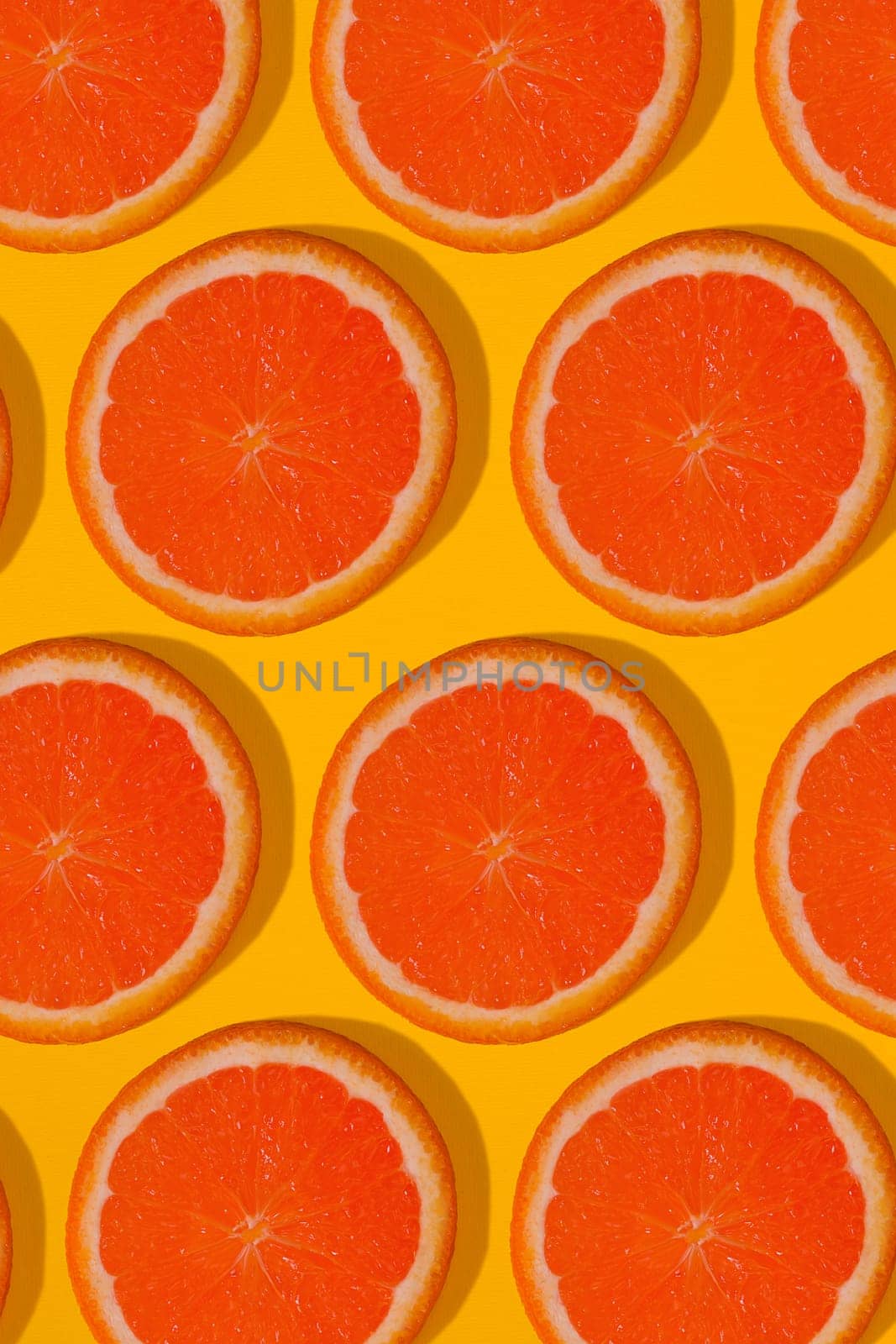 Grapefruit pattern on yellow background. Minimal flat lay concept. by nazarovsergey