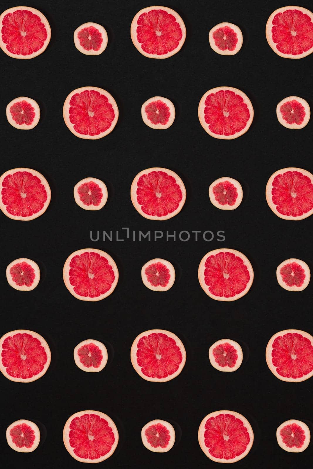 Grapefruit pattern isolated on black background. Flat lay by nazarovsergey