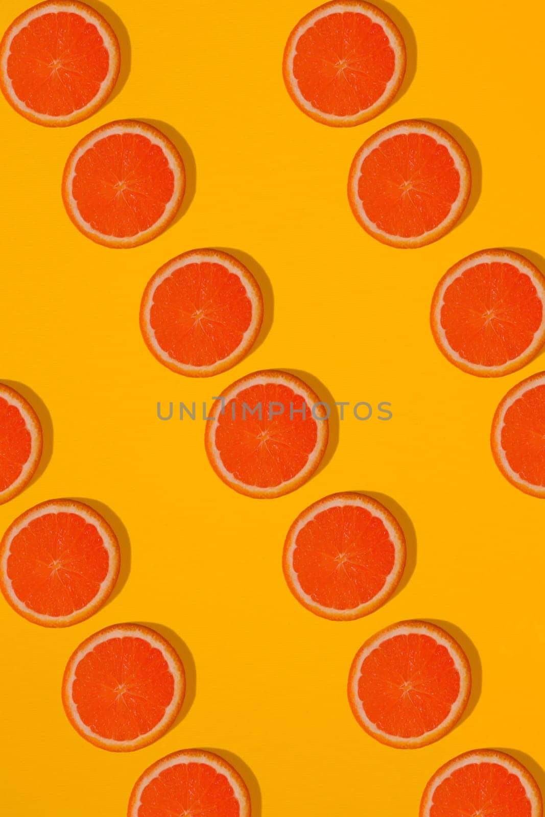 Grapefruit pattern on yellow background. Minimal flat lay concept. by nazarovsergey