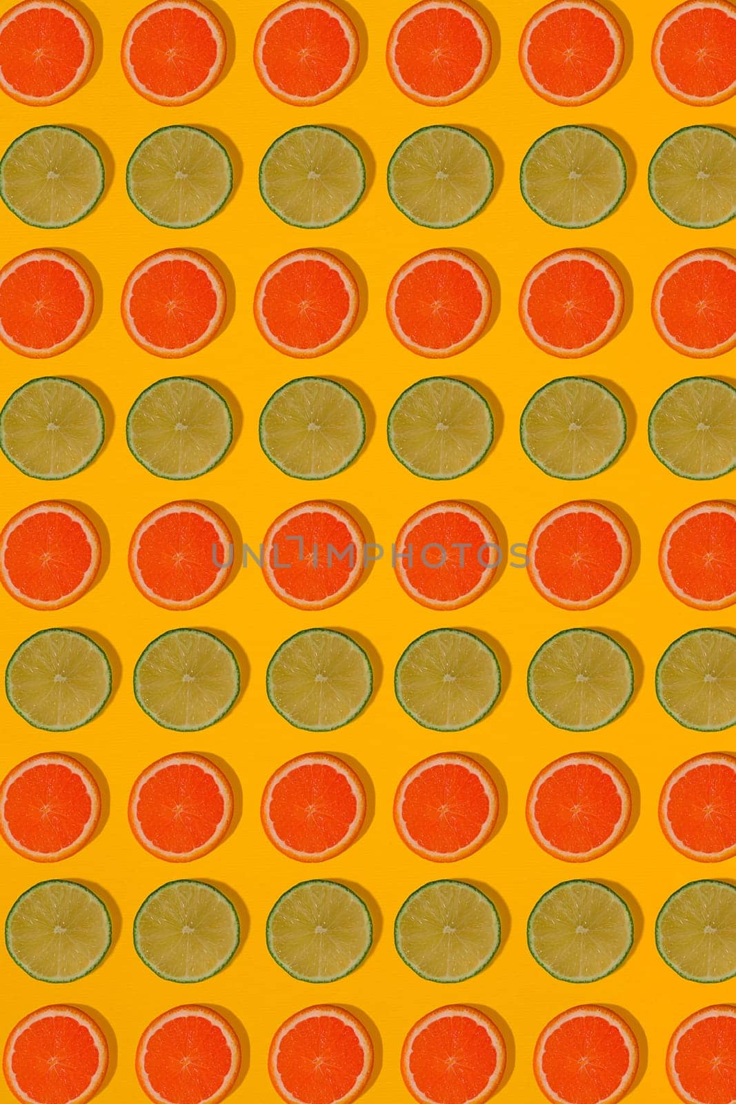 Grapefruit and lime pattern on yellow background. Minimal flat lay concept. by nazarovsergey