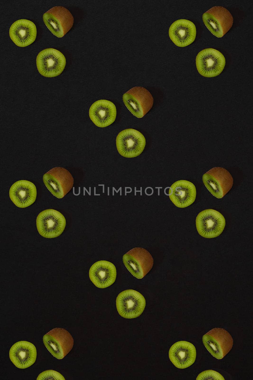 Pattern of kiwi. Top view of the sliced kiwi on black background. Minimal flat lay concept. by nazarovsergey