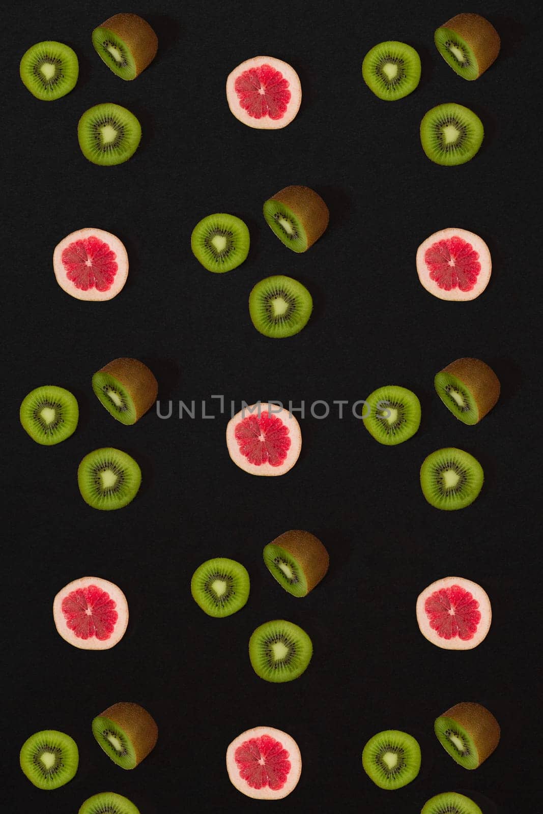 Grapefruit and kiwi pattern on black background. Minimal flat lay concept. Print