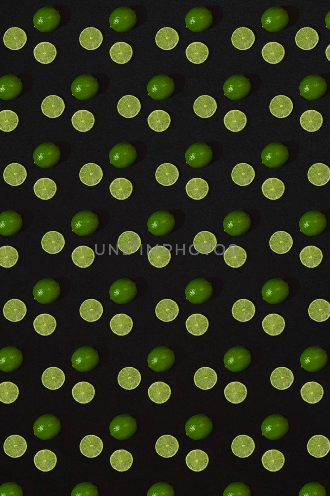 Lime pattern on black background. Minimal flat lay concept. by nazarovsergey