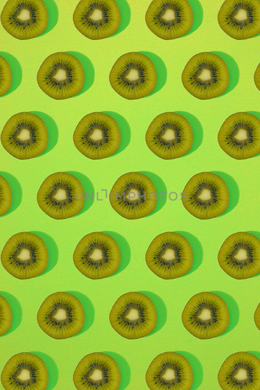 Pattern of kiwi. Top view of the sliced kiwi on green background. Minimal flat lay concept. Print