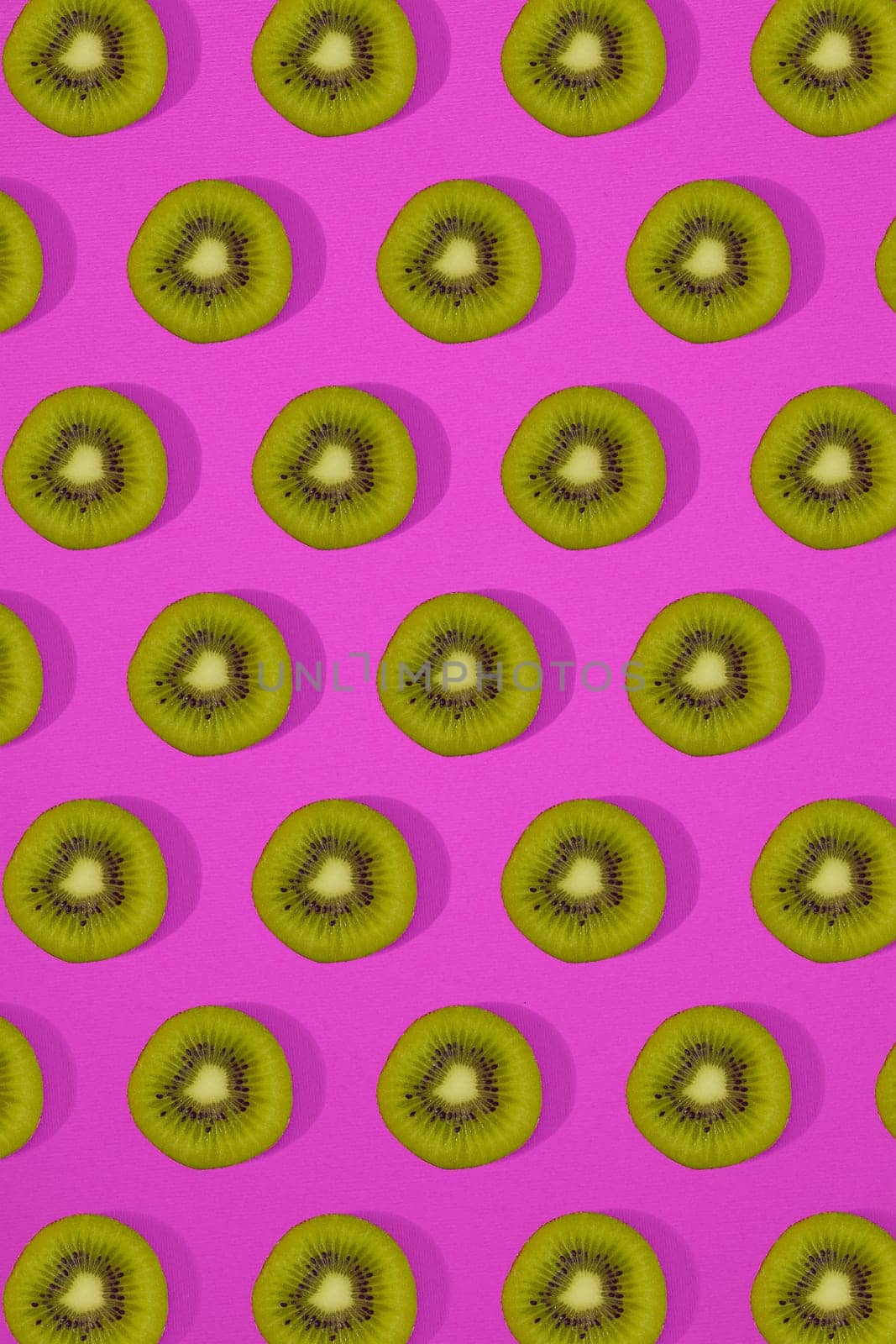 Pattern of kiwi. Top view of the sliced kiwi on pink background. Minimal flat lay concept. by nazarovsergey