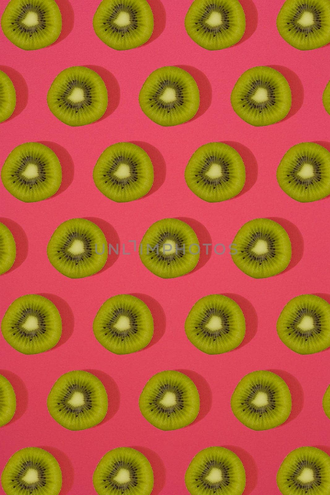 Pattern of kiwi. Top view of the sliced kiwi on pink background. Minimal flat lay concept. by nazarovsergey