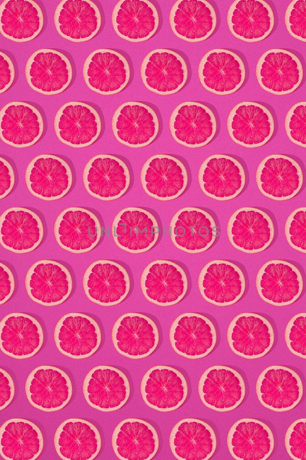 Grapefruit pattern on pink background. Minimal flat lay concept. by nazarovsergey