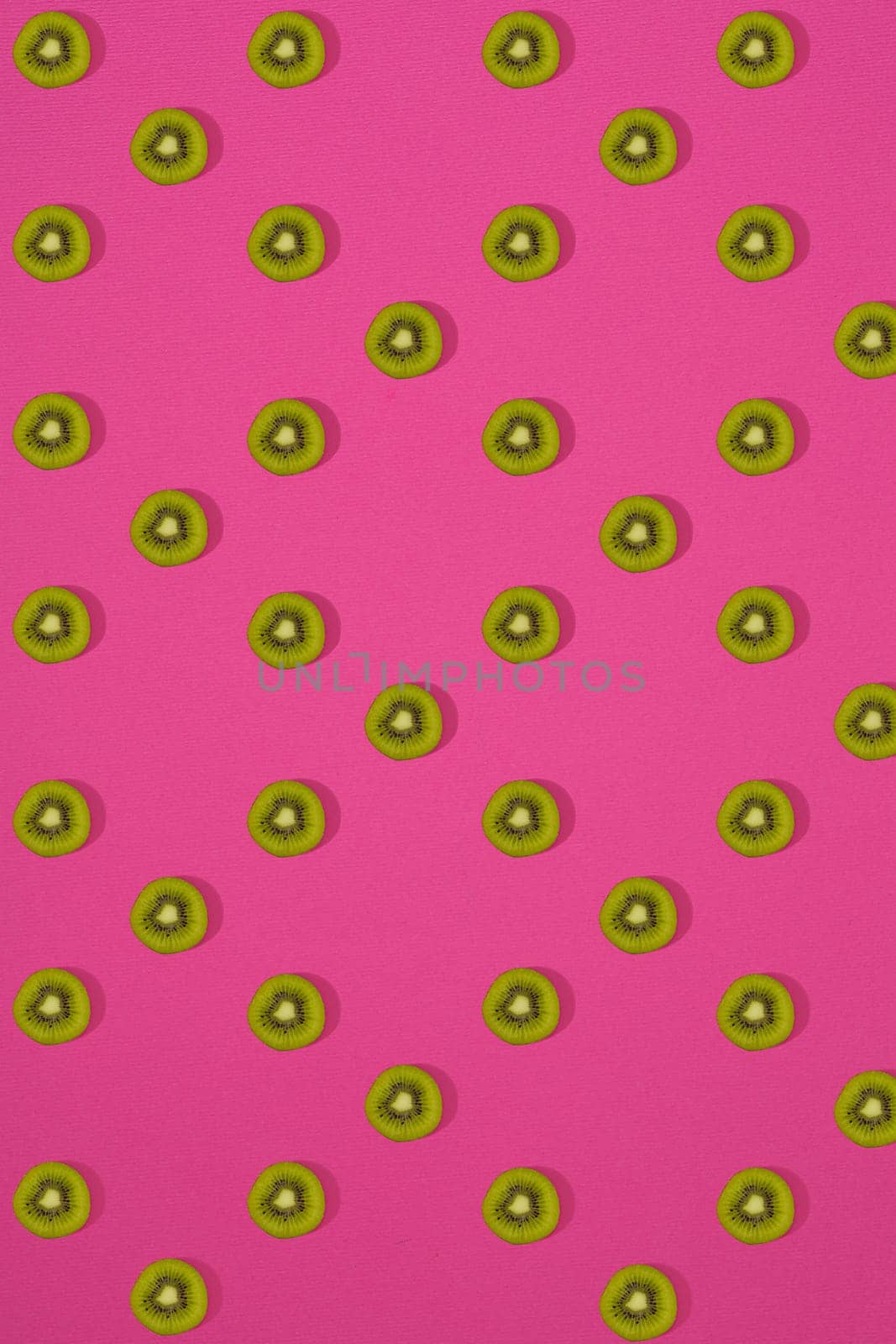 Pattern of kiwi. Top view of the sliced kiwi on pink background. Minimal flat lay concept. by nazarovsergey
