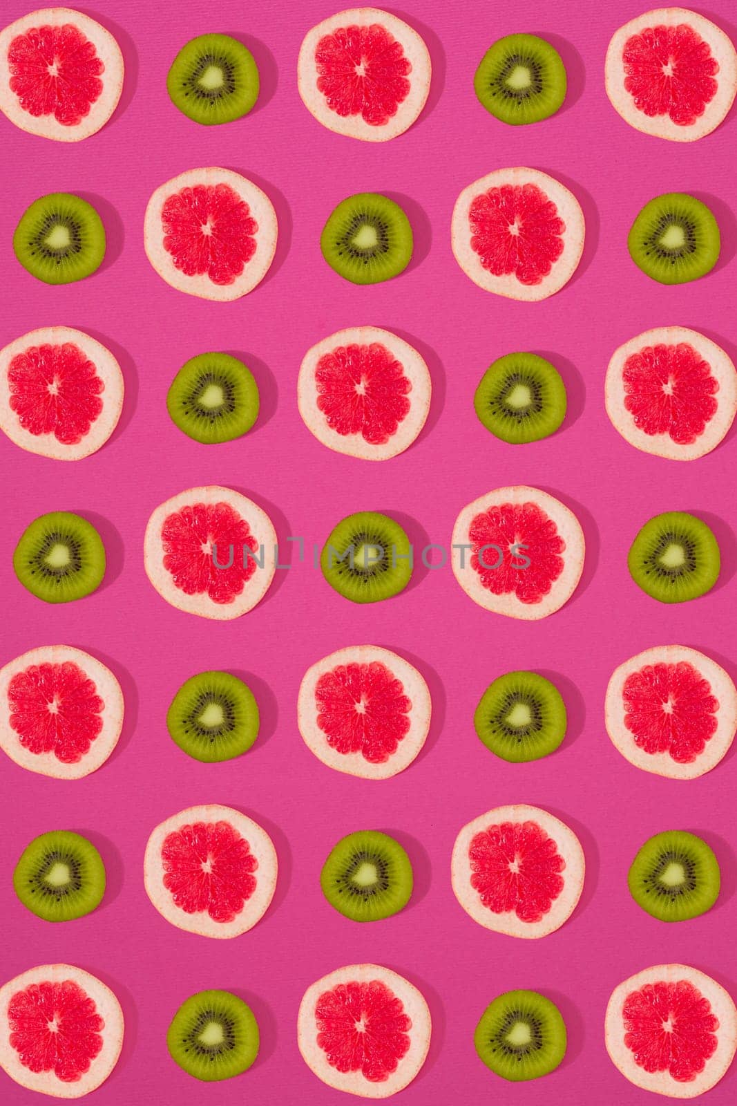 Grapefruit and kiwi pattern on pink background. Minimal flat lay concept. by nazarovsergey