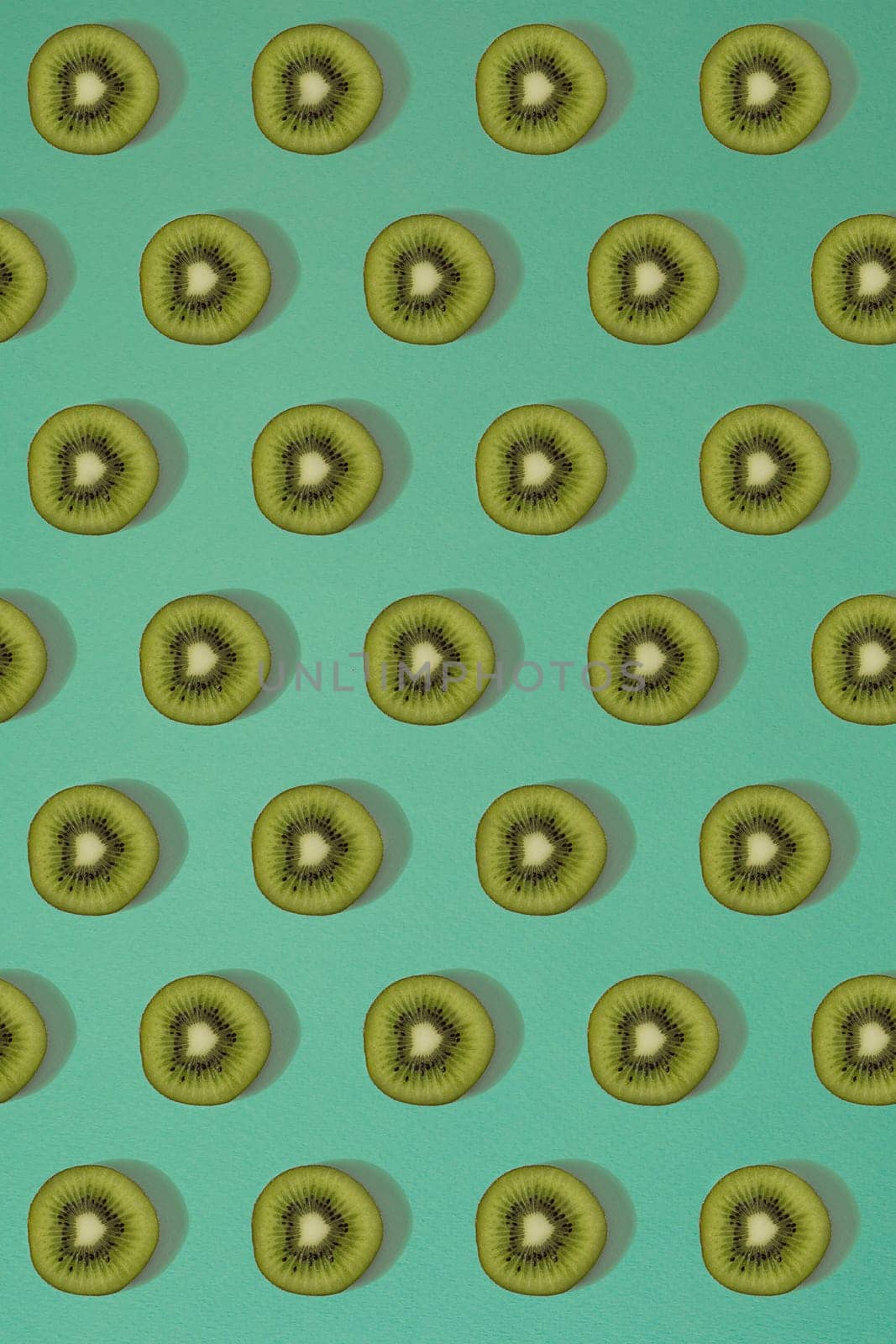 Pattern of kiwi. Top view of the sliced kiwi on blue background. Minimal flat lay concept. by nazarovsergey