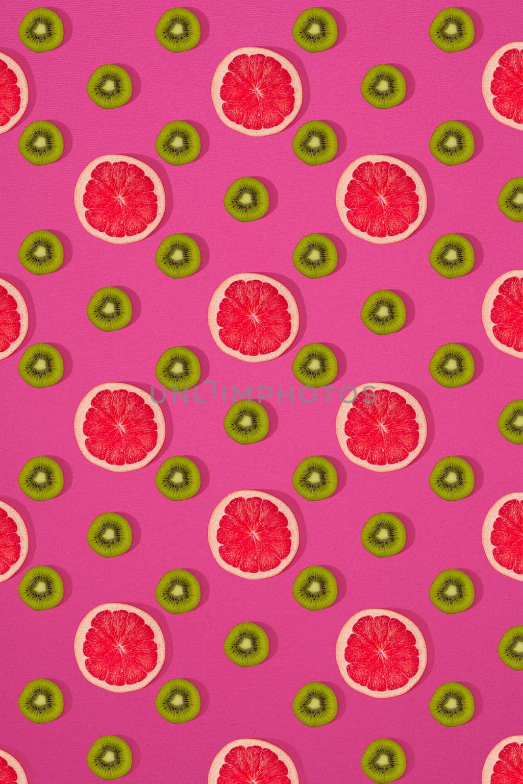 Grapefruit and kiwi pattern on pink background. Minimal flat lay concept. Print