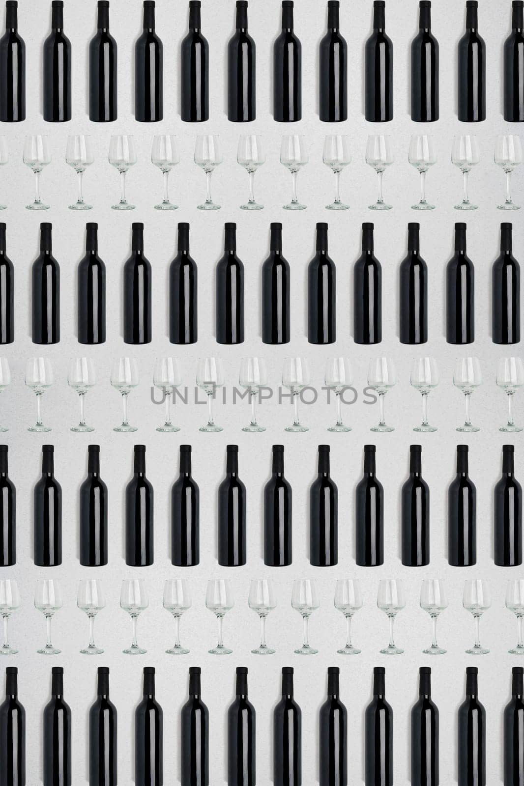 Dark wine bottles and glasses. Creative dark and textured abstract background. A lot of bottles of wine and glasses on a white background. Pattern