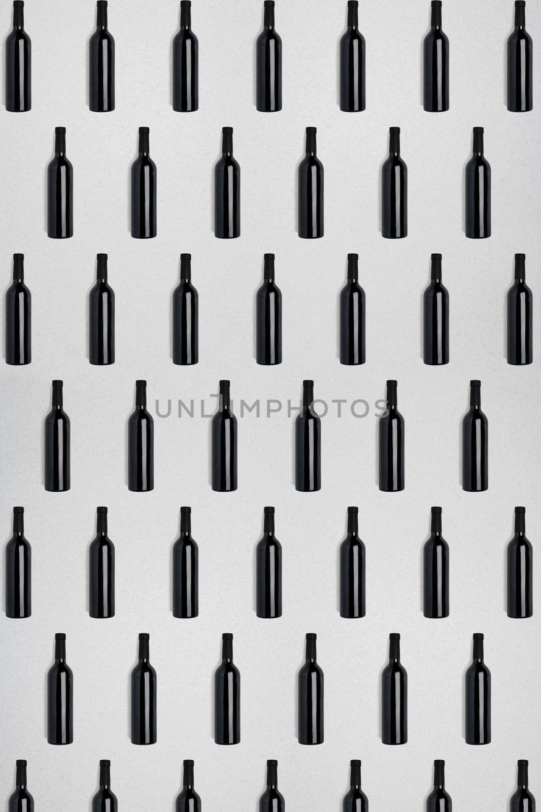 Dark wine bottles. Creative dark and textured abstract background. A lot of bottles of wine on a white background. Pattern