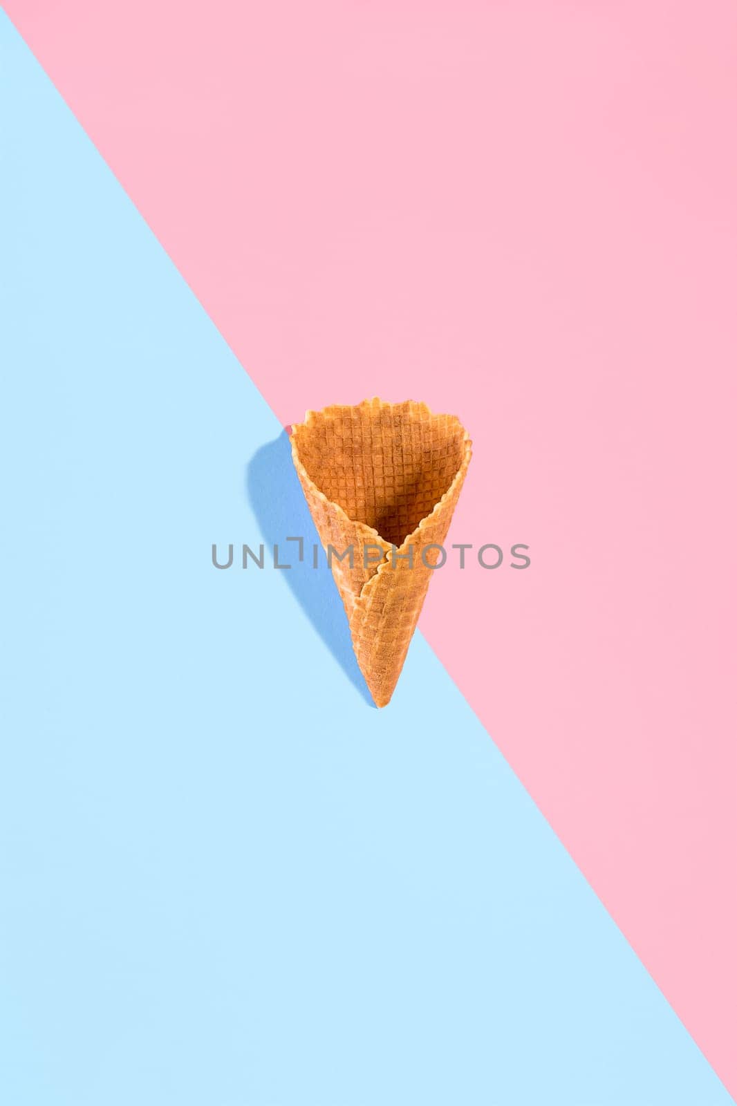 Sugar waffle cone for ice cream arranged in pattern on pink and mint background. The image with copy space can be used as a background for the design of the confectionery menu by nazarovsergey