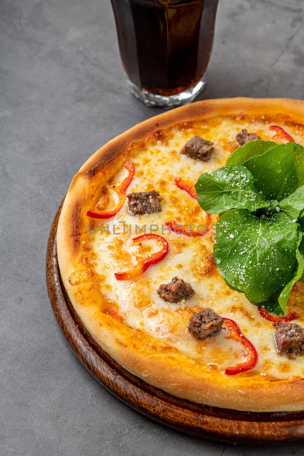 Pizza with paprika and roast beef on cutting board on stone table