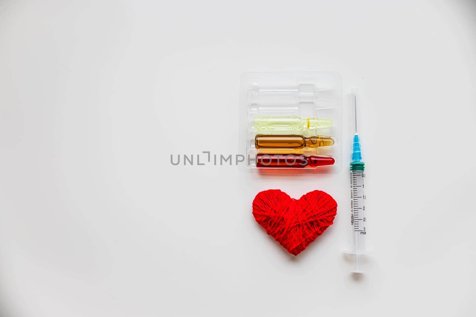 Medical colorful vials for injection syringe and red heart on a white background. Healthy heart.