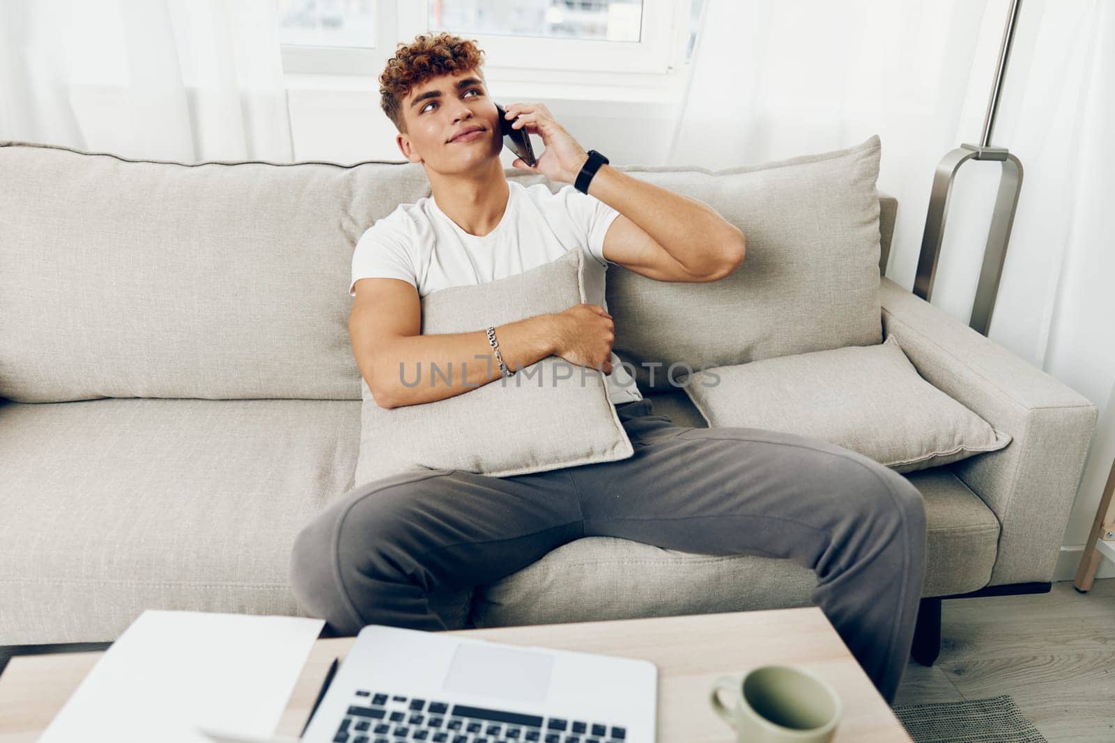 man interior sports phone home lifestyle using text message person sitting curly blissful young modern blogger holding smartphone student