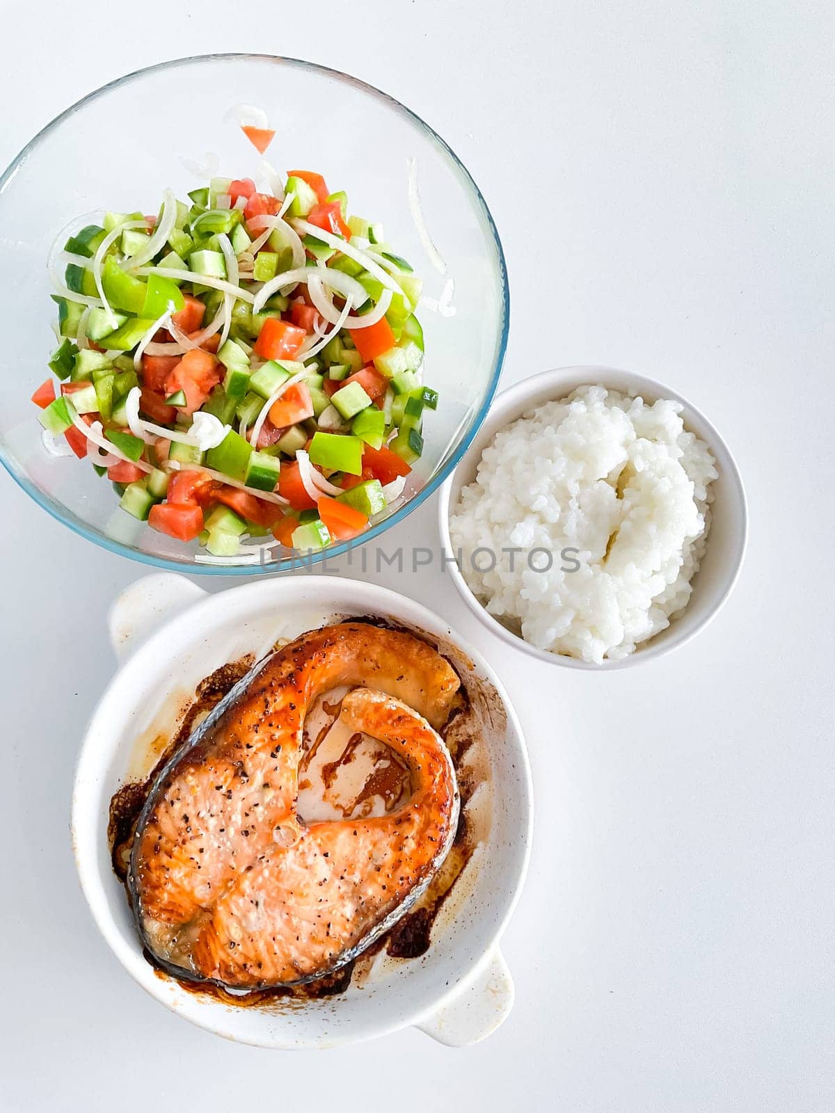 Healthy balanced meal lunch plate - baked salmon with rice and vegetables on a light background, top view