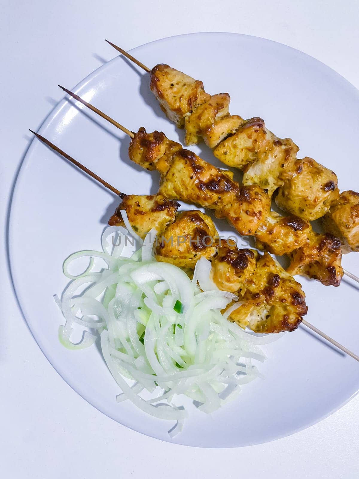 Traditional delicious turkey or chicken shish kebab skewer barbecue meat with tomatoes, pepper and sauce. Served on white kitchen table background. Natural light. Picnic bbq gourmet.