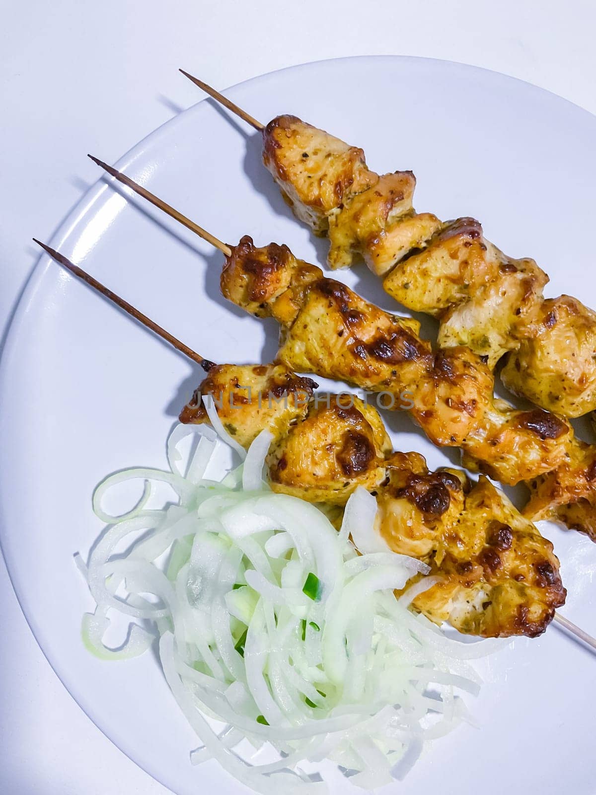 Traditional delicious turkey or chicken shish kebab skewer barbecue meat with tomatoes, pepper and sauce. Served on white kitchen table background. Natural light. Picnic bbq gourmet.