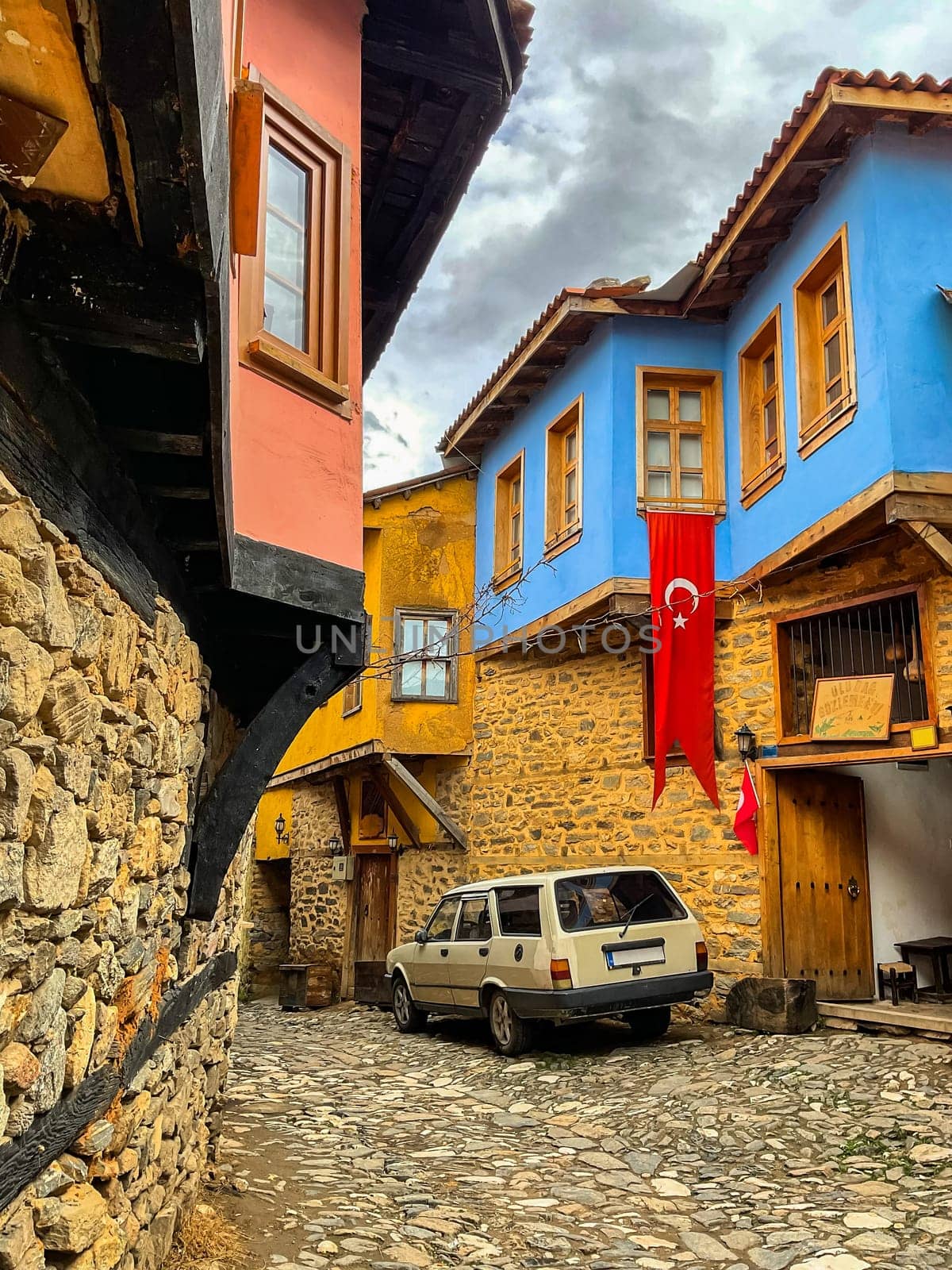 Cumalikizik village is a 700 years old Ottoman village in Turkey. Old Ottoman village in Bursa city, Turkey. Narrow street with old Ottoman houses and turkish flag