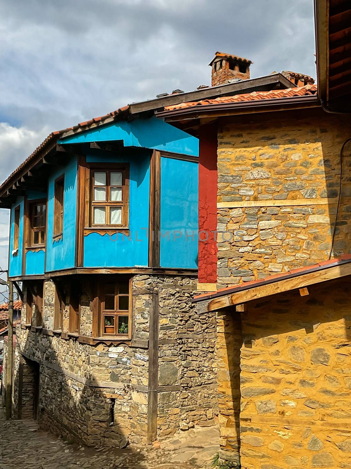 Cumalikizik village is a 700 years old Ottoman village in Turkey. Old Ottoman village in Bursa city, Turkey. Narrow street with old Ottoman houses and turkish flag