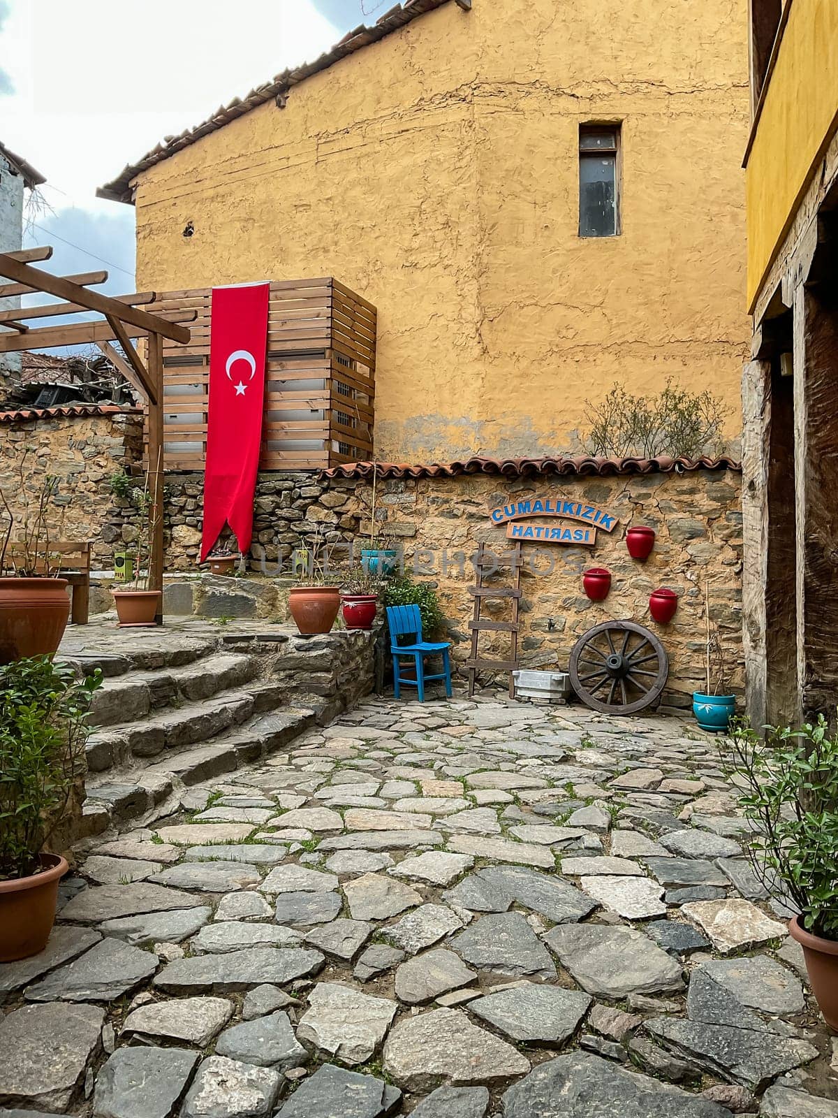 Cumalikizik village is a 700 years old Ottoman village in Turkey. Old Ottoman village in Bursa city, Turkey. Narrow street with old Ottoman houses and turkish flag